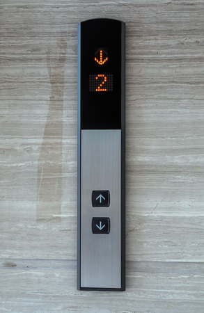Elevator Button up and down direction with down red light on granite background