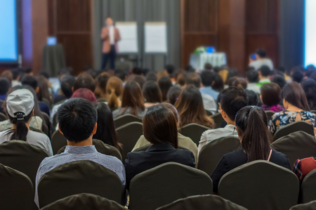 Speaker on the stage with Rear view of Audience in the conference hall or seminar meeting, business and education conceptの写真素材