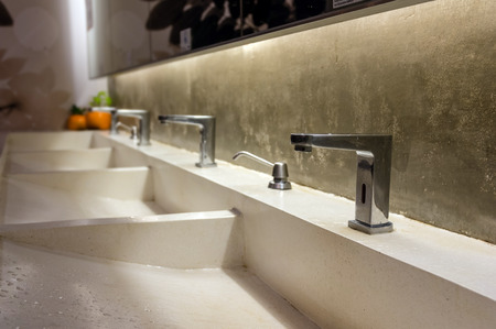 Chrome faucet with washbasin in modern toiletの写真素材