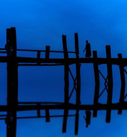 Sunset with silhouettes of monk on the U-Bein Bridge is the longest. in Amarapura ,Mandalay ,Myanmarの写真素材