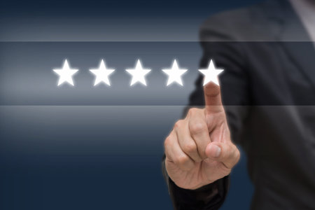 Businessman pointing five star symbol to increase rating of company or hotel on dark tone...