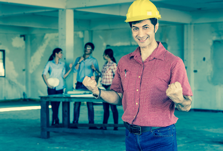 Portrait of Happy professional construction engineer wearing the safety helmet cheering action at the building site place background, industrial engineering conceptの写真素材