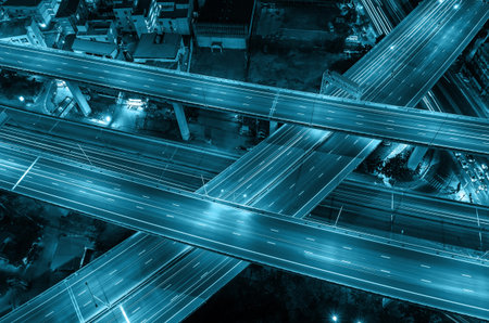 Top view of massive expressway at night with light of cars, transportation industrial concept