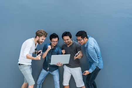 Group Of Asian and Multiethnic Business people with casual suit using each technology equipment with happy and celebrate action at the outdoor over the wall background, people business group conceptの写真素材