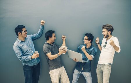 Group Of Asian and Multiethnic Business people with casual suit using each technology equipment with happy and celebrate action at the outdoor over the wall background, people business group conceptの写真素材