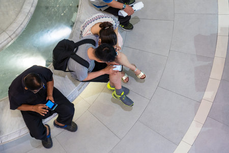 Lifestyle of people group sitting at the shopping mall and using modern smartphone device, female hands typing text message for social network via smart cellphone, business social networking conceptの写真素材