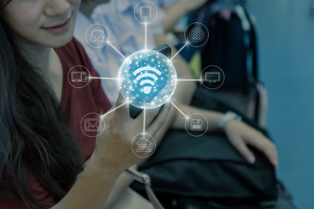 Closeup woman using the smart mobile phone in the BTS Skytrain rails or MRT subway for travel and online shopping with omni channel in the big city, lifestyle and transportation conceptの写真素材