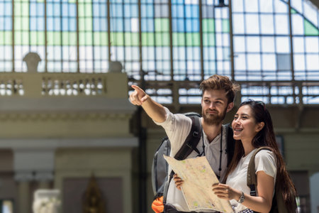 Multiethnic Travellers are looking the destination and holding the map at the train station, Travel and transportation conceptの写真素材