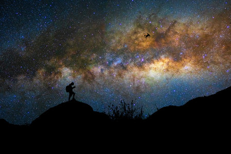 Silhouette of photographer with drone over the milky way on the dark sky background, photographer...