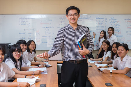 Portrait of Asian teacher standing when Giving Lesson to group of College Students in the classroom, University education conceptの写真素材