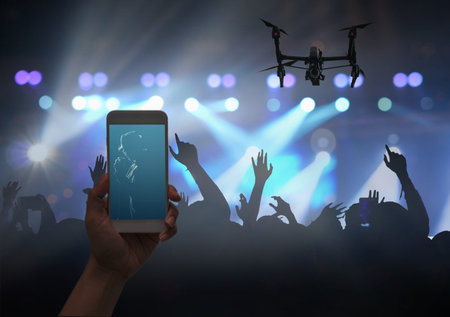 Female hand holding mobile smart phone and Drone flying taking video record or Live stream of...