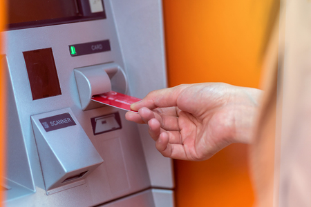 Closeup woman withdrawing the cash via ATM, business Automatic Teller Machine conceptの写真素材