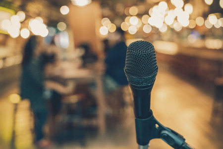 Microphone over the Abstract blurred photo of people group having the meeting in public working space or seminar room, misucal and education with modern lifestyle conceptの写真素材