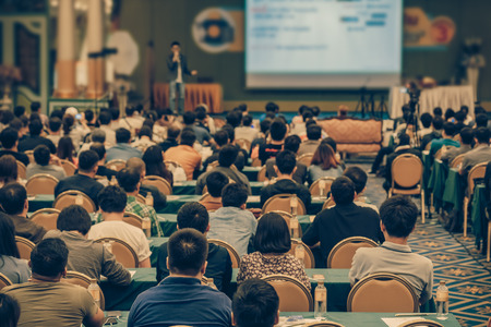 Rear view of Audience in the conference hall or seminar meeting which have Speakers are Brainstorming and talking on the stage, business and education about investment conceptの写真素材