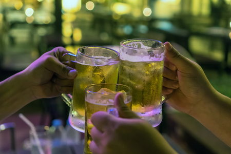 Three Glasses of Beer cheers together between friend in the low light bar and restaurant. relax and drink conceptの写真素材