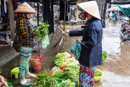 CAI RANG, VIETNAM - AUG 11, 2018 : Undefined Female trader sitting for sale Vegetable on the floor with traditional market on August 11, 2018 at port of Cai rang market, can tho province, vietnam.のeditorial素材