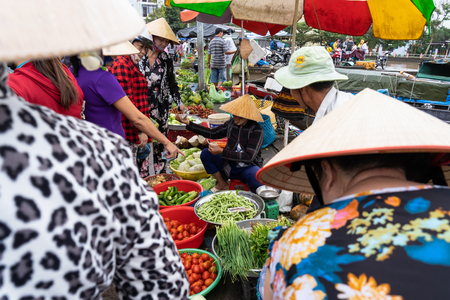 CAI RANG, VIETNAM - AUG 11, 2018 : Undefined Female trader sitting for sale Vegetable on the floor with traditional market on August 11, 2018 at port of Cai rang market, can tho province, vietnam.のeditorial素材
