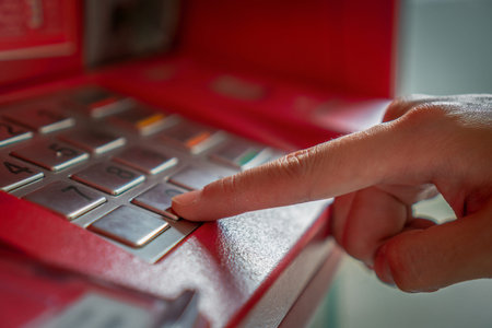 Close up of a fingers pressing password code when withdrawing the cash at the ATM