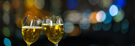Clinking with two beer mug or glasses over the photo blurred of cityscape for celebrate, party and celebrate with happy new year concept, Banner and web page or cover templateの写真素材