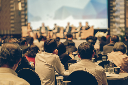 Rear view of Audience listening Speakers on the stage in the conference hall or seminar meeting, business and education about investment conceptの写真素材