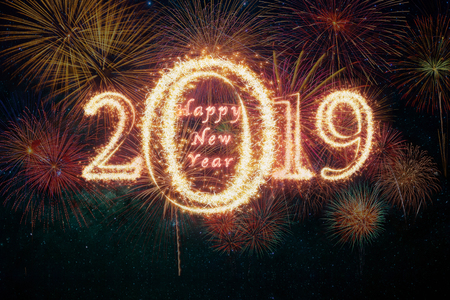 Happy new year 2019 written with Sparkle firework on fireworks with dark background, celebration and greeting cards conceptの写真素材