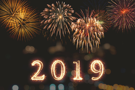 Happy new year 2019 written with Sparkle firework on fireworks with dark background, celebration and greeting cards conceptの写真素材