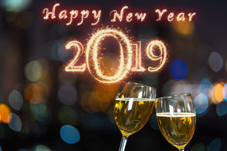Happy new year 2019 written with Sparkle firework on Clinking with two beer mug or glasses over the...