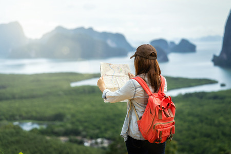 Back side of Asian woman traveler looking the map for travel with backpacker at Fantastic Landscape of samed nang chee view point, travel and holiday conceptの写真素材