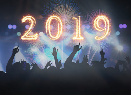 2019 written with Sparkle firework on Concert crowd in silhouettes of Music fanclub with show hand...