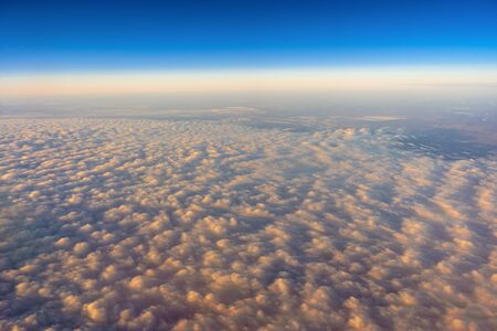 golden cloud over the blue sky Out side above view from airplane side windows when sunrise, transportation and traveler conceptの写真素材