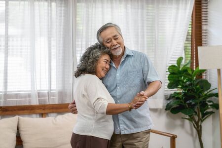 Asian couple Grandparent dancing and hugging together with happy feeling in house, romantic and lover with valentine or anniversary, Long live and Elderly society, Warm family and happiness conceptの写真素材