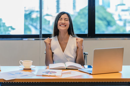 Polygonal brain shape of an artificial intelligence with AI text and various icon of smart city Internet of Things Technology over Asian businesswomen happiness celebrating when doing online shoppingの写真素材