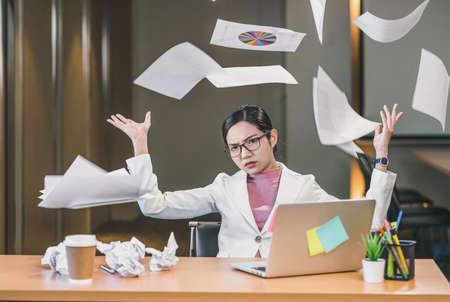 Asian businesswoman angry throwing papers over the herself in office when job fail, unsuccessful project, work hard and Overworked and stressed Concept,の写真素材