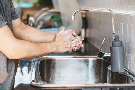 Closeup-up Asian man hand washing with faucet water in kitchen at home, Health care pandemic ,...