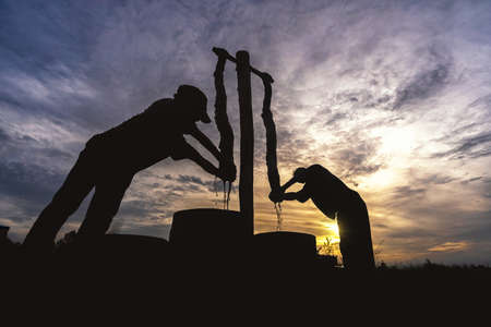 Silhouette of vietnamese worker dyeing the silk when sunrise in tan chau village, Angian, vietnam, latest village of ancient culture to dyed, tradition and conserve culture conceptの写真素材