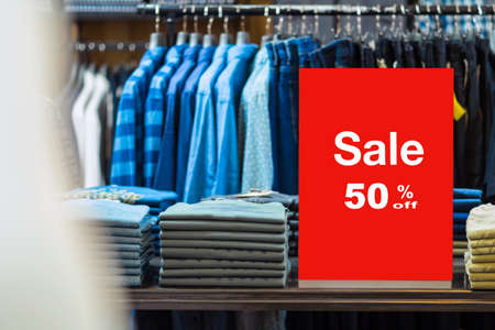 sale 50 off mock up advertise display frame setting over the stack of jeans and clothes line in the...