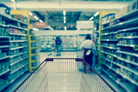 Abstract blurred photo of store with trolley in department store bokeh background, business supermarket and shopping blurred and background conceptの写真素材