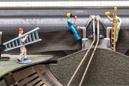 Team of miniature workers performing maintenance activitiesの写真素材