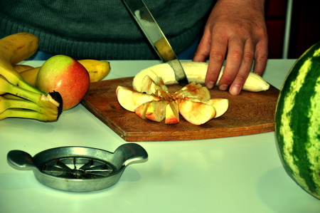 male hand cuts the banana and lay the fruit on the tableの写真素材