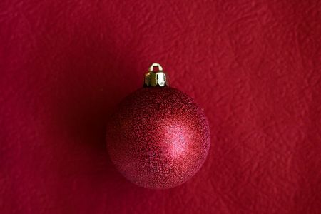 Christmas bauble on dark red background - see moreの写真素材