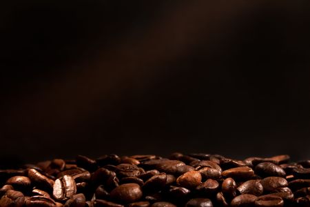 hot coffee beans with a smoke on dark backgroundの写真素材