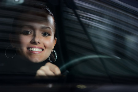 young beautiful woman driving a car and smiling