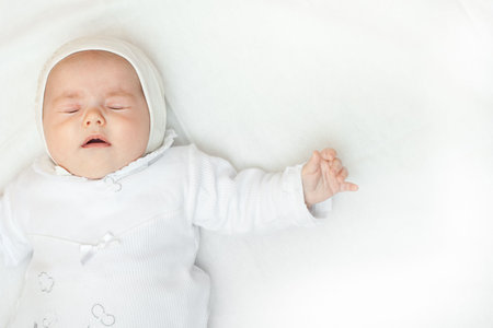 cute little baby girl lying down on a bed closeup