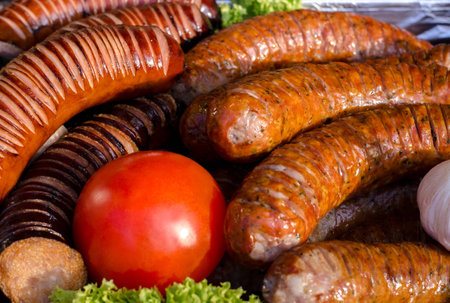 assorted sausages grilled on skewers on a large plate, mushrooms on the grill. Street festival food.の写真素材