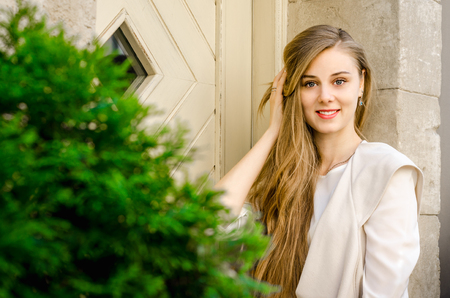 Smiling bussines casual woman with long hair in cafe city street sunny day backgroundの写真素材