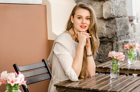 Smiling bussines casual woman with long hair in cafe city street sunny day backgroundの写真素材
