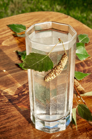 Glasses of birch sap juice birch branches on wooden table background. Healthy and vitamin food spring useful vitamin nutrition fresh drink.の写真素材