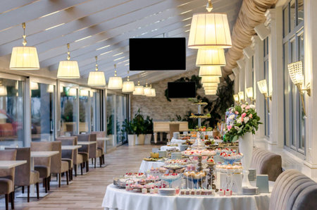 Delicious wedding reception candy bar dessert table full with cakes and sweets and a flower vase with hydrangeas on the backgroundの写真素材