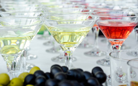 Glasses of martini with olives and glasses with cognac. Alcoholic beverages served at bar. Club atmosphere.の写真素材