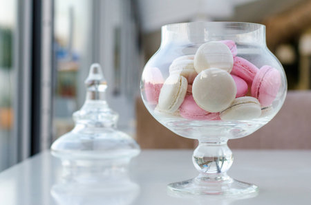 Macarons in a glass vase on a tableの写真素材